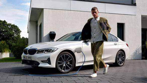 BMW Série 3 Berline hybride rechargeable 2021 G20 branchée à une borne de recharge, vue de trois quarts avant BMW Série 3 Berline hybride rechargeable 2021 G20, branchée à une borne de recharge, vue de trois quarts avant