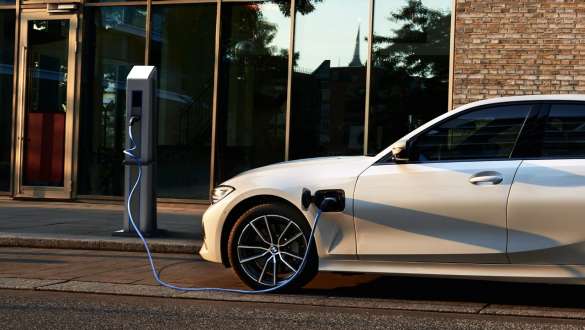 BMW Série 3 Berline hybride rechargeable 2021 G20, vue de profil BMW Série 3 Berline hybride rechargeable 2021 G20, vue de profil à une borne de recharge