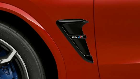 BMW X4 M Competition, ouïes M avec insigne du modèle. Extérieur de la BMW X4 M Competition en Toronto Rot metallic, ouïes M en Schwarz hochglänzend avec insigne du modèle.