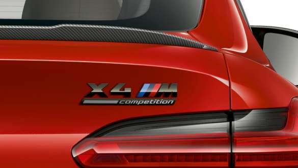 BMW X4 M Competition, arrière avec insigne "X4 M Competition". Extérieur de la BMW X4 M Competition en Toronto Rot metallic, vue en gros plan de l’arrière avec becquet arrière en carbone et insigne "X4 M Competition".