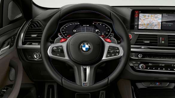 BMW X4 M Competition, volant M en cuir. Intérieur de la BMW X4 M Competition, habitacle, volant M en cuir avec touches multifonctions.
