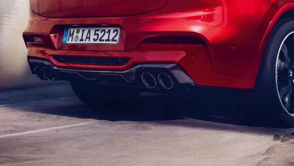 Système d’échappement M sport. Extérieur de la BMW X4 M Competition en Toronto Rot metallic, vue arrière avec système d’échappement M sport et diffuseur en carbone.