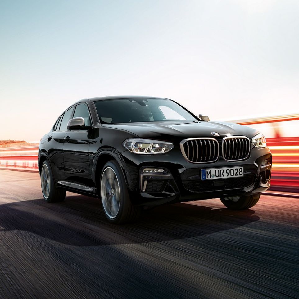 BMW X4 M40i vue de trois quarts avant. Extérieur des BMW X4 M40i en Saphierschwarz metallic, vue de trois quarts avant gauche avec bandes lumineuses.