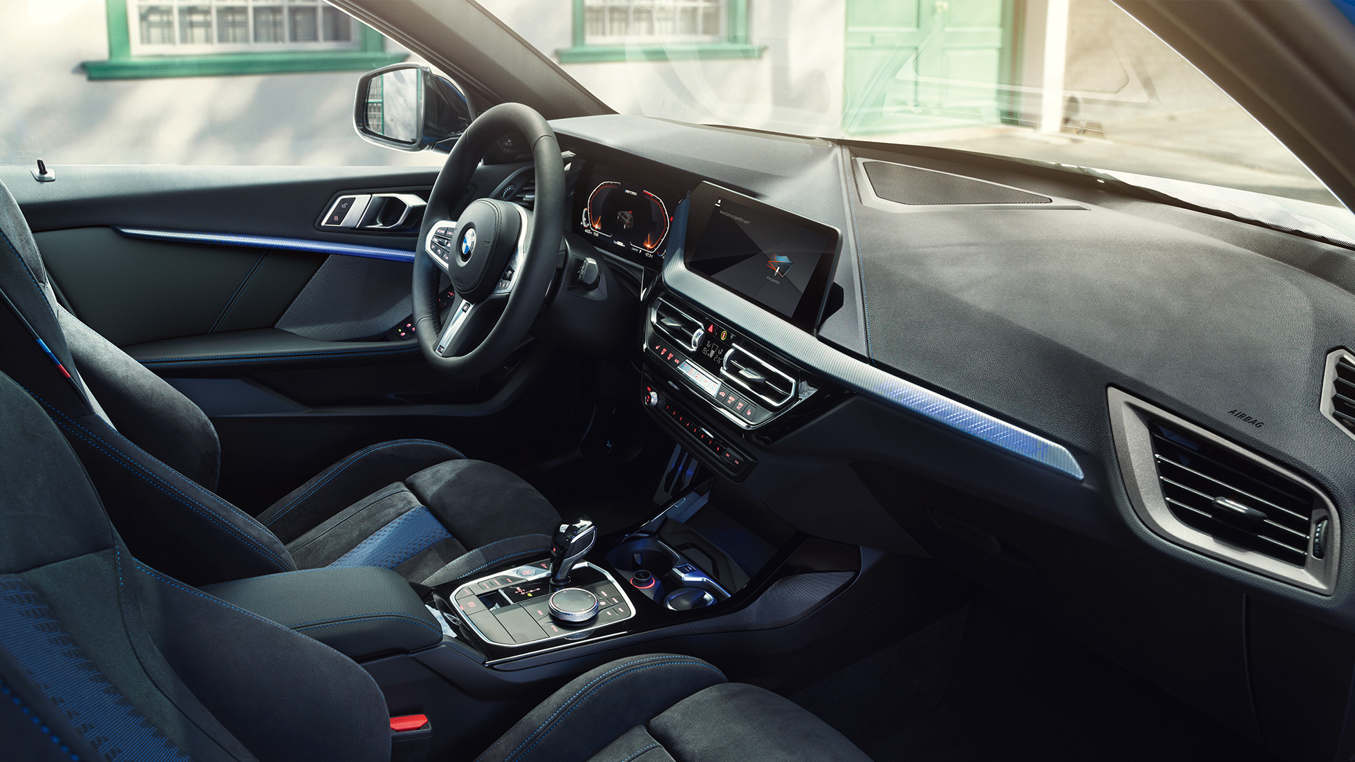 Aménagement intérieur sportif de la BMW Série 1 Le poste de conduite de la BMW Série 1 avec sièges M sport, volant M en cuir et inserts de décoration éclairés.