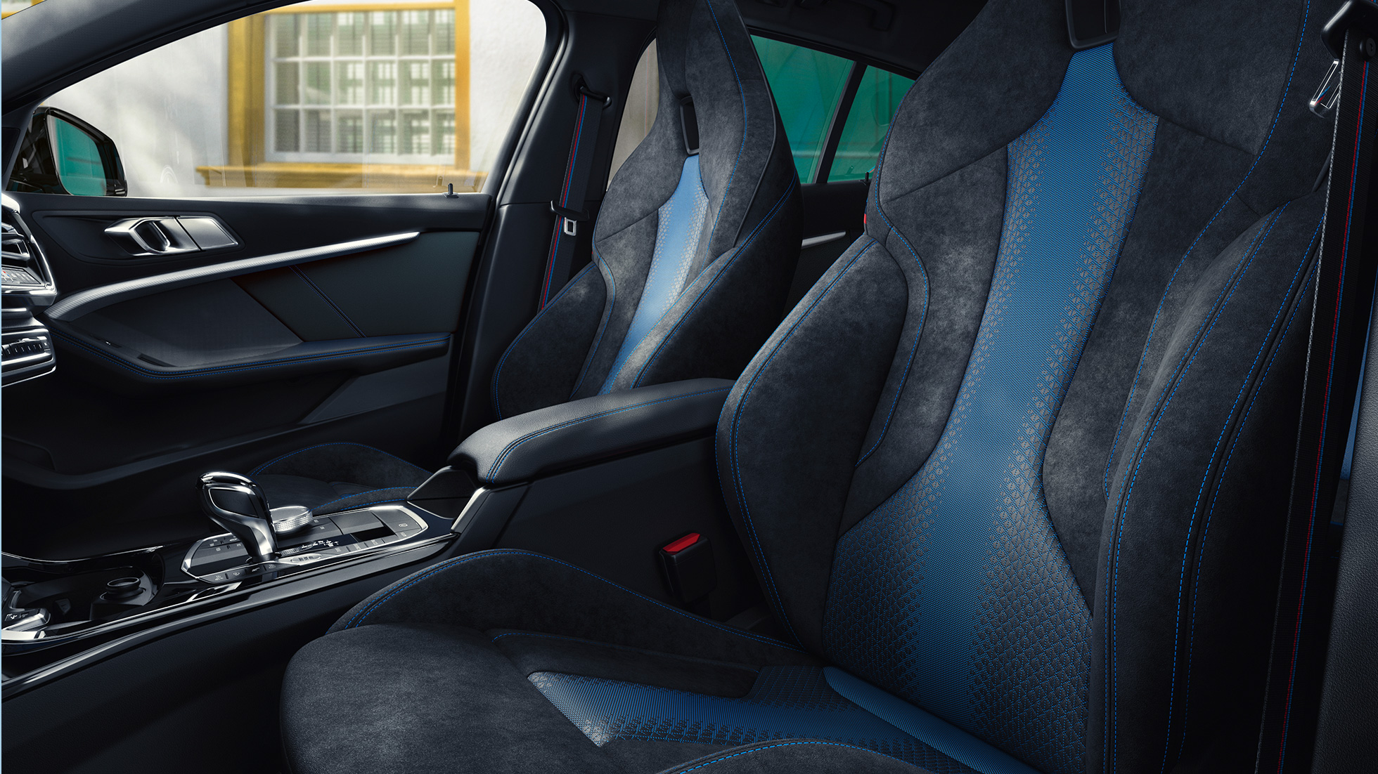 Sièges M sport. Sièges M sport au galbe ergonomique de la BMW Série 1, avec surpiqûres contrastées bleues et appuie-têtes intégrés.