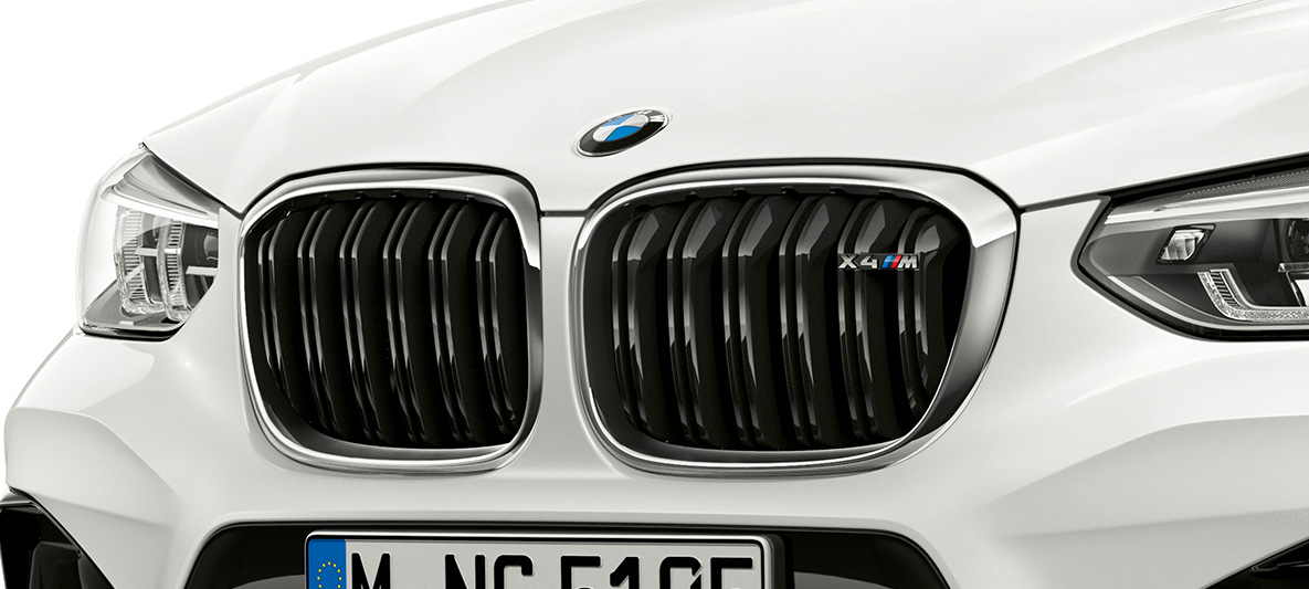 BMW X4 M, naseaux M. Extérieur de la BMW X4 M en Alpinweiß, avant, naseaux M avec accents chromés et insigne du modèle.