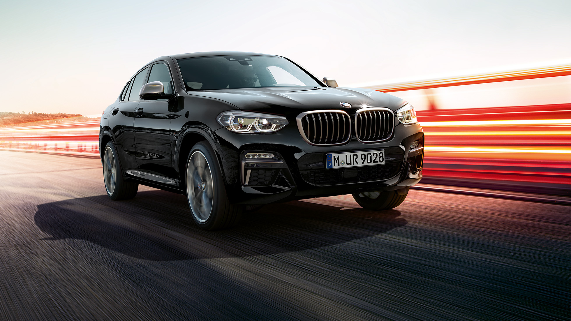 BMW X4 M40i vue de trois quarts avant. Extérieur des BMW X4 M40i en Saphierschwarz metallic, vue de trois quarts avant gauche avec bandes lumineuses.