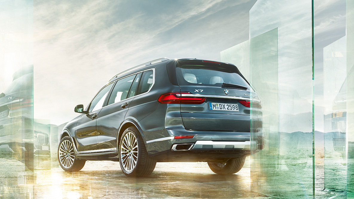 Le confort et la dynamique de conduite de la BMW X7 Vue de trois quarts arrière de la BMW X7 devant un décor abstrait