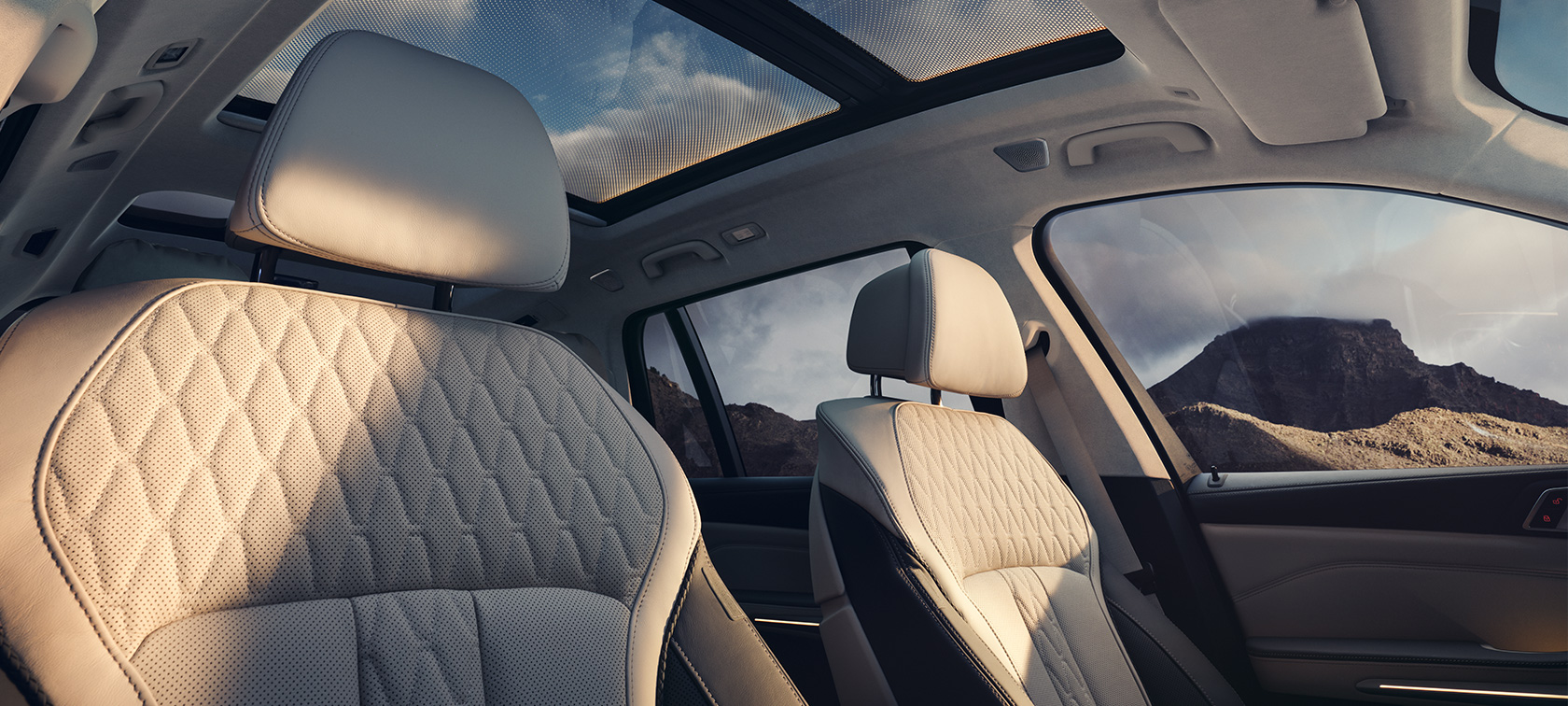Habitacle de la BMW X7 G07 LCI – vue vers l’arrière depuis le côté passager, au-dessus des sièges avant
