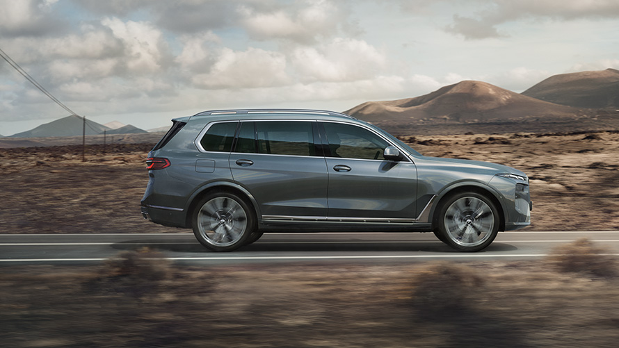 BMW X7 G07 LCI Design Pure Excellence Sparkling Copper Grey métallisé – vue de côté BMW X7 G07 LCI Design Pure Excellence Sparkling Copper Grey métallisé – vue de côté sur la route