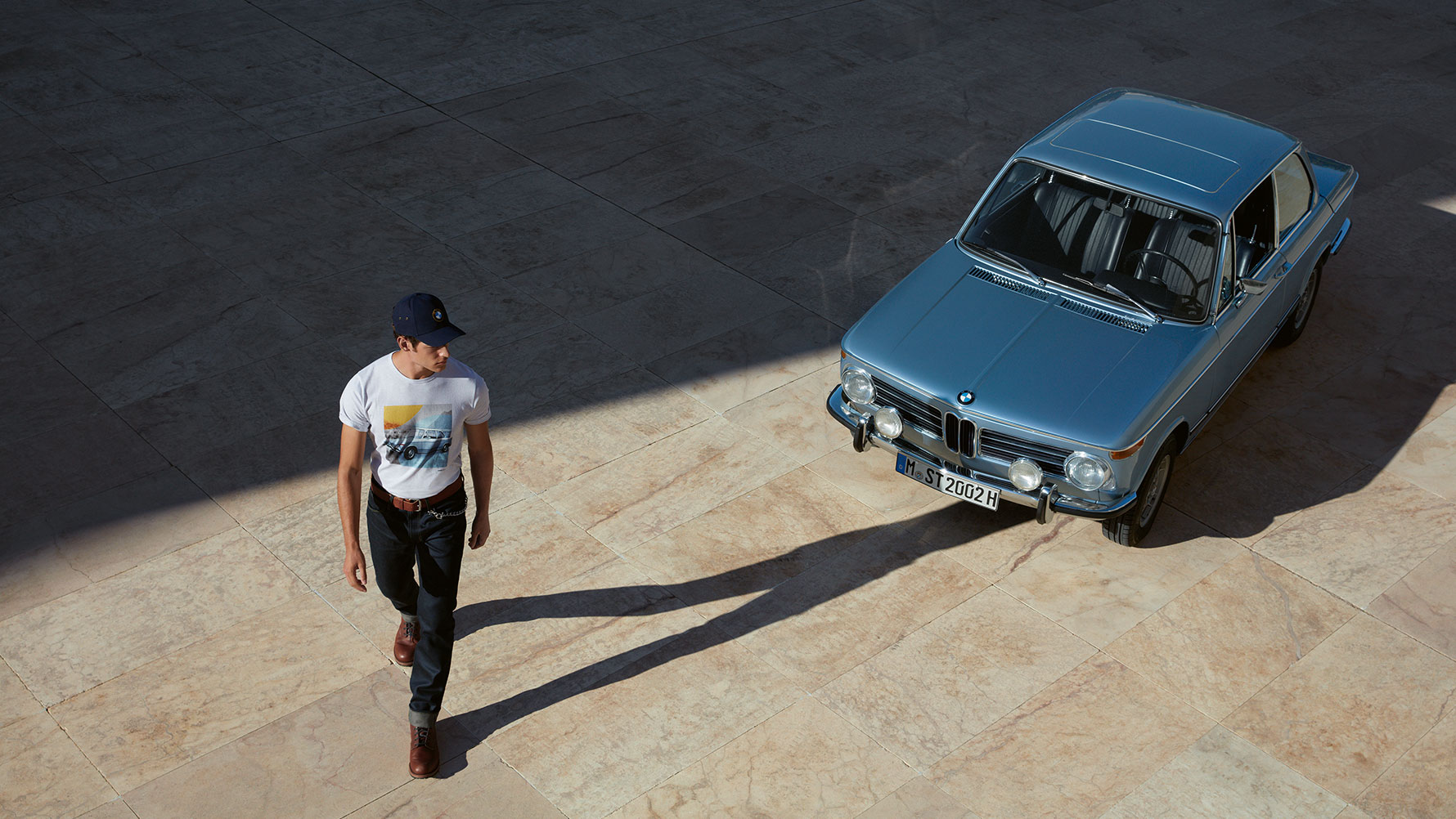 L’homme portant un T-shirt de la Collection BMW Classic est présenté en train d’admirer une BMW Classique. L’homme portant un T-shirt de la Collection BMW Classic est présenté en train d’admirer une BMW Classique.