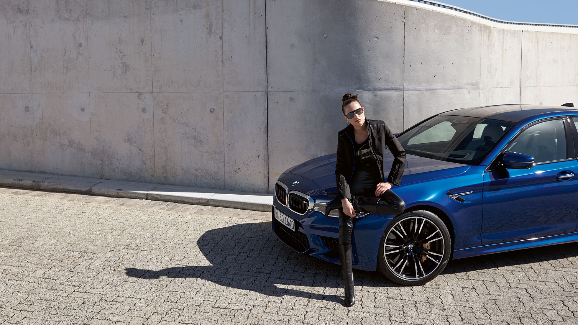 Collection BMW M. La jeune femme est présentée portant une veste en cuir BMW M.